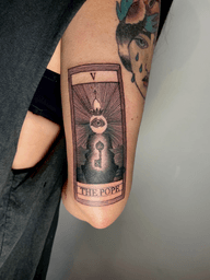 Get a striking blackwork tarot card tattoo featuring The Pope motif, executed in fine line illustrative style by the talented artist Robin Rossi.