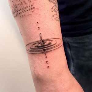Unique black and gray tattoo of water drop with reflection, expertly done by Alex Caldeira.