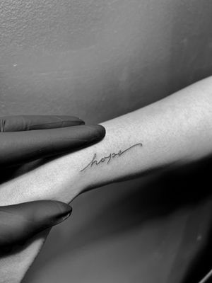 Fine line tattoo with small lettering by Inna, symbolizing harmony and connection.