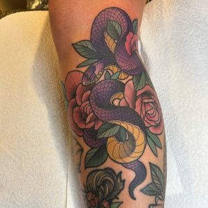 A stunning neo-traditional tattoo featuring a snake and flower motif, expertly done by Lawrence Canham.