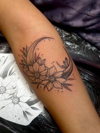 Experience the intricate beauty of dotwork in this illustrative tattoo by artist Kat Jennings. Featuring a mystical moon and delicate flower motif.