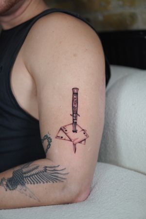 Unique black and gray illustrative tattoo featuring a dagger, cards, king and ace of spades by artist Joshua Williams.