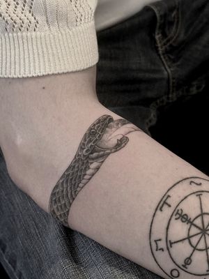 Check out this stunning black and gray illustrative snake tattoo by Saka Tattoo. The ouroboros motif symbolizes eternal cycles of life and rebirth.