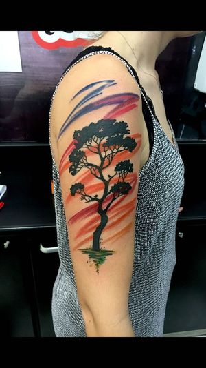 Vibrant watercolor tree design on upper arm by talented artist Sandro Secchin.