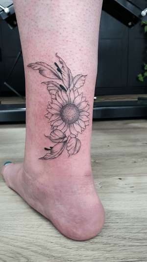 Capture the essence of nature with this illustrative tattoo featuring this beautiful sunflower and leaves #fineline #floral #finelinetattoo