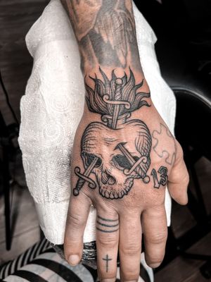 Illustrative tattoo by Alexandra Mulhall featuring a skull, sword, engraving, and woodcut elements with a medieval twist.