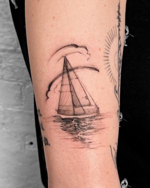 Get lost in the tranquil sea with this fine line black and gray illustrative sailboat tattoo by the talented artist Alex Caldeira.