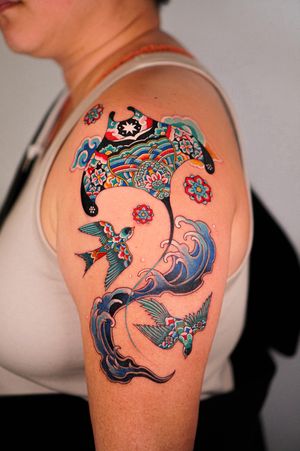Experience the beauty of the sea with this illustrative tattoo featuring birds, flowers, and traditional Korean dancheong patterns by HWIZI.