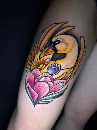 A stunning neo traditional tattoo by Hamid featuring a majestic swan surrounded by colorful flowers and jewel accents.