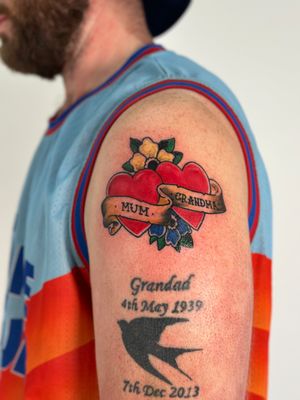 Celebrate your family with this traditional tattoo featuring a heart, flower, and banner. Expertly done by tattoo artist Oliver Soames.