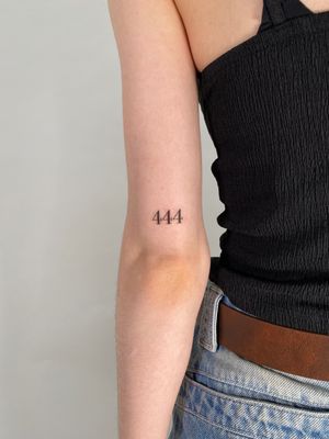 A tattoo by Chloe Hartland featuring a stylish lettering design of an angel number motif.