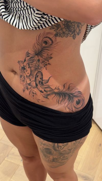 A stunning black and gray tattoo featuring a peacock, fish, flowers, feathers, and koi, meticulously drawn by Ion Caraman.