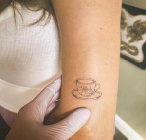 Elegant black and gray illustrative teacup tattoo by the talented artist Alina Amberland. Perfect for tea lovers!