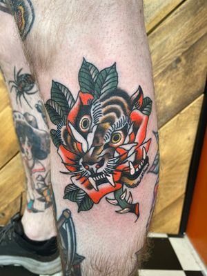 Experience the blend of traditional and abstract styles in this stunning tattoo by Megan Foster. A striking tiger and delicate rose create a unique and eye-catching design.