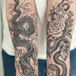 A black and gray tattoo combining a traditional Japanese dragon with intricate floral elements, skillfully created by Amandine Canata.