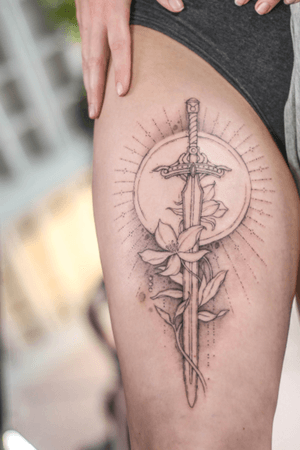 Get inspired by this illustrative tattoo featuring a unique combination of a sun, flower, and sword, expertly done by artist George Francis.