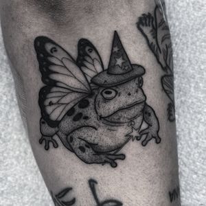 Immerse yourself in a magical world with this intricate dotwork tattoo featuring a wise wizard, mystical fairy, and a whimsical frog by renowned artist Barbara Nobody.