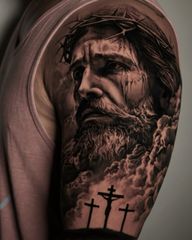 Jesus and three crosses on the shoulder, black and grey realism with clouds, light and heavy contrast. KAZENTATTOO, Los Angeles.