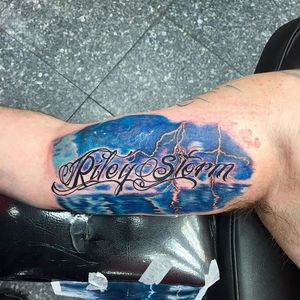 Name tattoo with storm background done at villagepoptattoo #nametattoo #storm #lighting #water #wave 