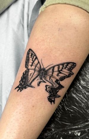 Unique black and gray tattoo combining a butterfly motif with glitch elements, done in dotwork and illustrative style by Liberty C Tattoo.