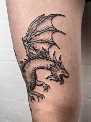 Illustrative woodcut style tattoo by Alexandra Mulhall featuring a fierce dragon in a medieval design.