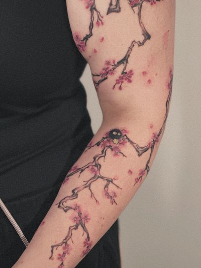 Anime tattoo featuring a tree with soot sprites and cherry blossoms, inspired by Studio Ghibli, by Takko San.