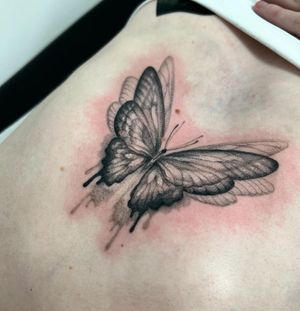Experience the delicate beauty of a black and gray dotwork butterfly tattoo expertly done by the talented artist Ellie Shearer.
