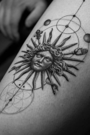 Experience fine line and micro realism by Light Grays in this stunning black and gray tattoo featuring a geometric Greek sun motif.
