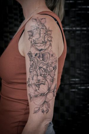 Explore the whimsical world of Alice with this fine line tattoo by Steffan Eagle featuring intricate floral designs and the iconic caterpillar character.