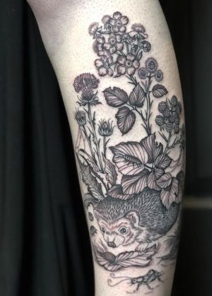 Adorn your skin with a whimsical illustration of a hedgehog surrounded by blooming flowers and plants by the talented artist Amandine Canata.