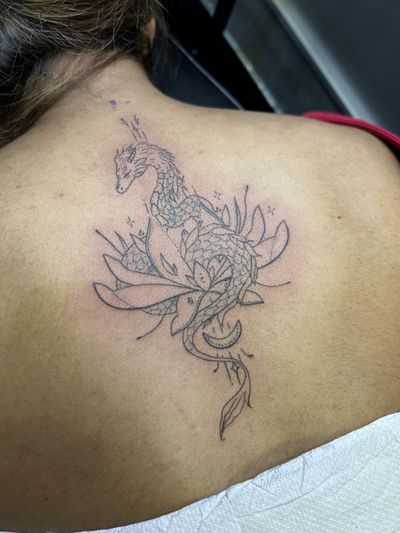 Inna creates a delicate tattoo featuring a dragon intertwined with a lotus flower using fine line ornamental style.