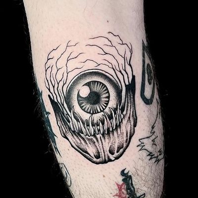 Get inked with a chilling blackwork eye tattoo by renowned artist Ker Kusterbeck. This unique dotwork design is sure to turn heads.