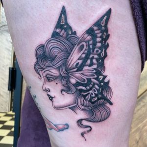 Discover the beauty of this illustrative traditional tattoo featuring a majestic butterfly and elegant lady by artist Megan Foster.