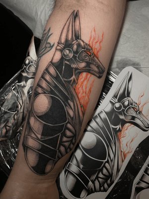 A striking black and gray tattoo of Anubis, the Egyptian god of the afterlife, in a modern neo-traditional style by Kat Jennings.