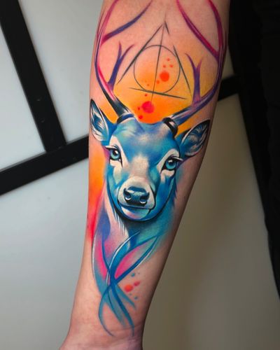 An illustrative tattoo combining a deer and Harry Potter elements in a unique watercolor style by Cloto.tattoos.