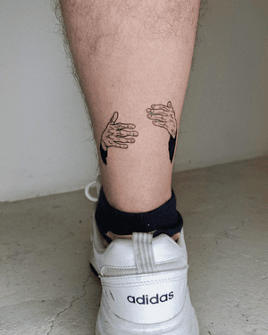 Illustrative blackwork tattoo by Alona Hamova depicting two hands in a warm hug, symbolizing love and connection.