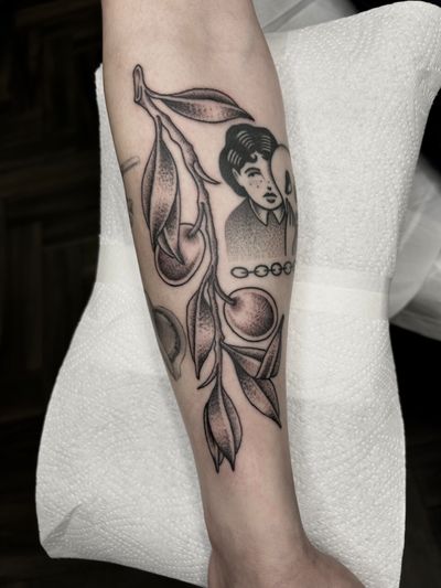 A traditional black and gray tattoo of a tree branch with fruits, expertly done by Barney Coles.