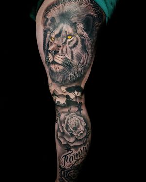 Black and gray realism tattoo depicting a lion and rose in the vast savannah landscape, by Jaydip Kheni.