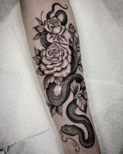 A stunning black and gray tattoo by Amandine Canata, featuring a snake and rose motif. Perfect for covering up scars.