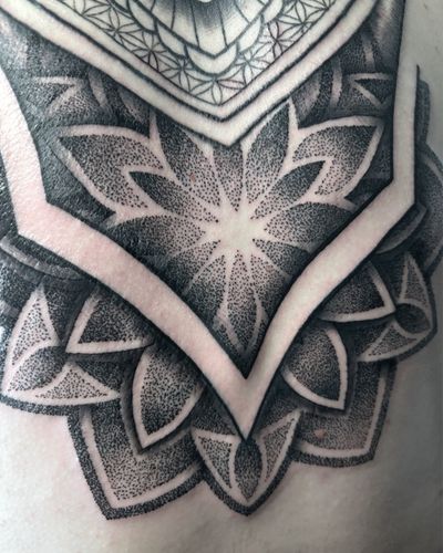 A stunning black and gray mandala pattern tattoo created by Alice Hope Tattoo, featuring intricate geometric elements.