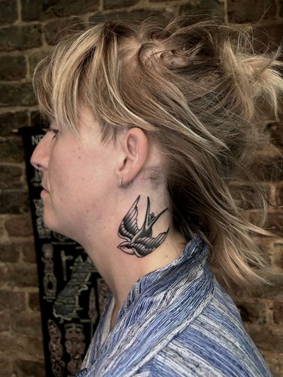 Barney Coles' traditional black_and_gray swallow tattoo captures the bird's elegance and beauty in intricate detail.