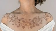 Delicate ivy leaves fine-line ivy leaves tattoo, seamlessly wrapping across the collar bones and chest, made with a freehand method by a female London-based tattoo artist