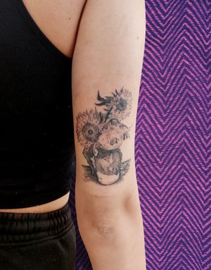 Experience the beauty of nature with this stunning black and gray hand-poked illustrative tattoo of a sunflower in a vase by the talented artist Rachel Howell.