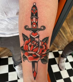 Beautiful traditional tattoo design featuring a rose and dagger, crafted by the talented artist Megan Foster.
