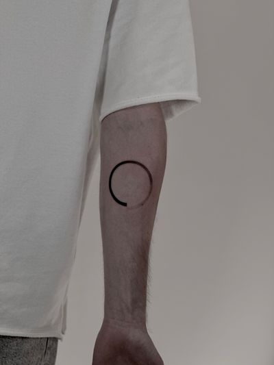 A blackwork, geometric tattoo by Saka Tattoo featuring a perfect, harmonious enso circle motif.