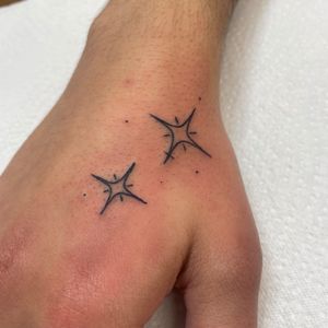 Minimal fine line tattoo featuring a delicate star design, expertly crafted by renowned artist Cappi.