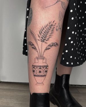 Beautiful tattoo of a vase and plant designed by Alessia Lo Piccolo, showcasing intricate illustrative style.