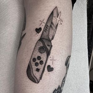 Unique dotwork illustration featuring a Nintendo Switch console, joycon, and knife by tattoo artist Barbara Nobody.
