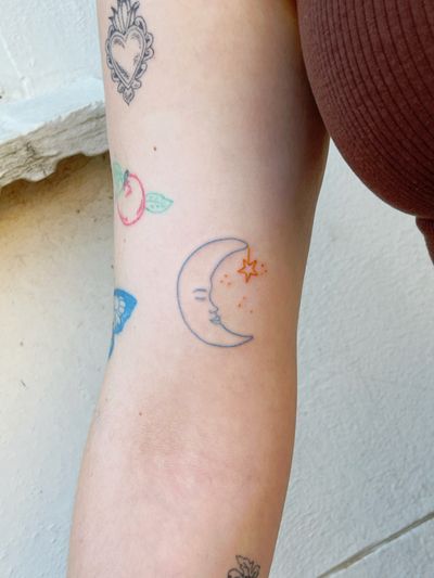 Laura's fine line, ignorant tattoo featuring a delicate moon and star motif.