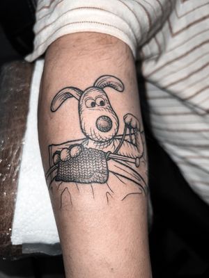 Illustrative tattoo featuring Wallace & Gromit inspired dog engravings with a woodcut and knitting motif.